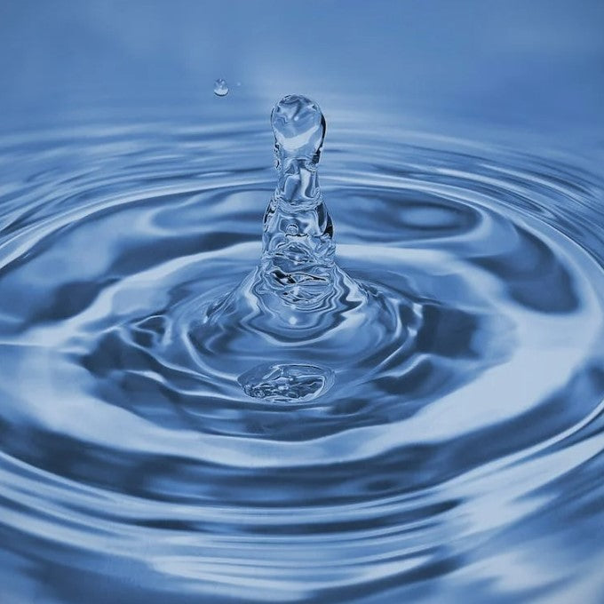 Close-up of clean running water rippling as a drop lands on the surface