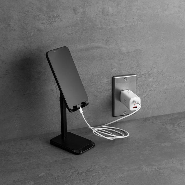 Phone on a stand charging from a wall outlet through a grantclassic charger