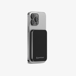 TITANSHIELD Solid-State Power Bank in black, attached magnetically to an iPhone | grantclassic