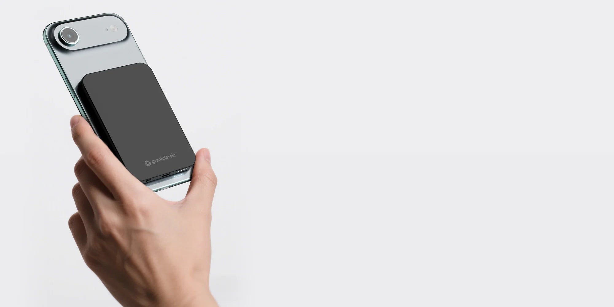 TITANSHIELD Air magnetic power bank on the back of an iPhone, charging wirelessly at 15W